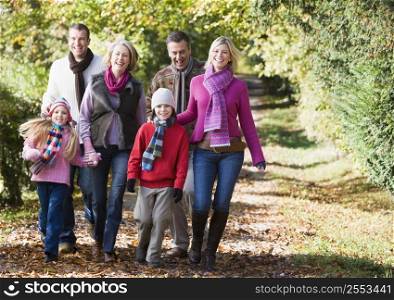 Family walking outdoors in park and smiling