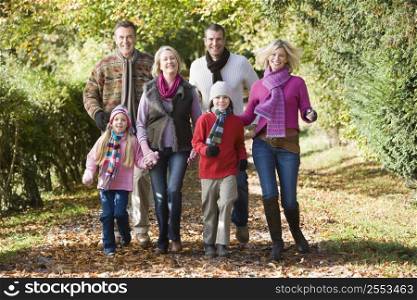 Family walking outdoors in park smiling
