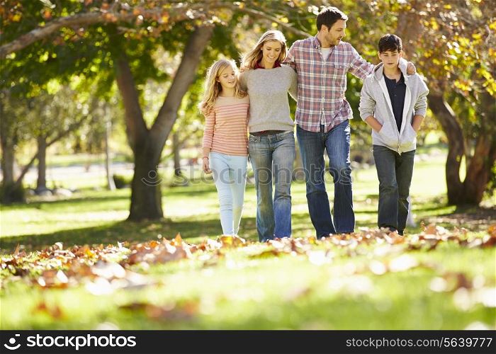 Family Walking Through Autumn Woodland