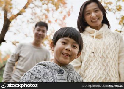 Family walking through the park in the autumn, portrait