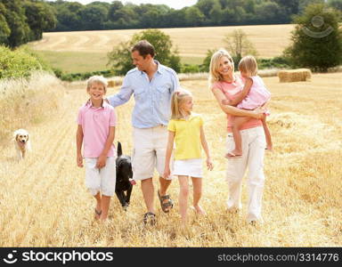 Family Walking Together Through Summer Harvested Field