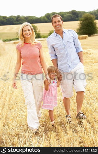 Family Walking Together Through Summer Harvested Field