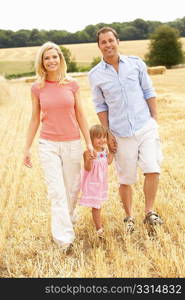 Family Walking Together Through Summer Harvested Field