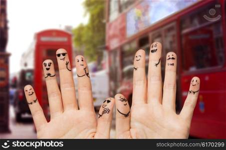 family, wedding, marriage, people and body parts concept - close up of two hands showing fingers with smiley faces over london city street and red bus background