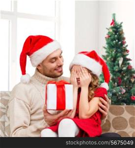family, winter holidays and people concept - smiling daughter with closed eyes waiting for present from father over living room and christmas tree background