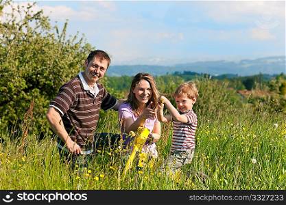 Family with a little boy playing in the grass on a summer meadow