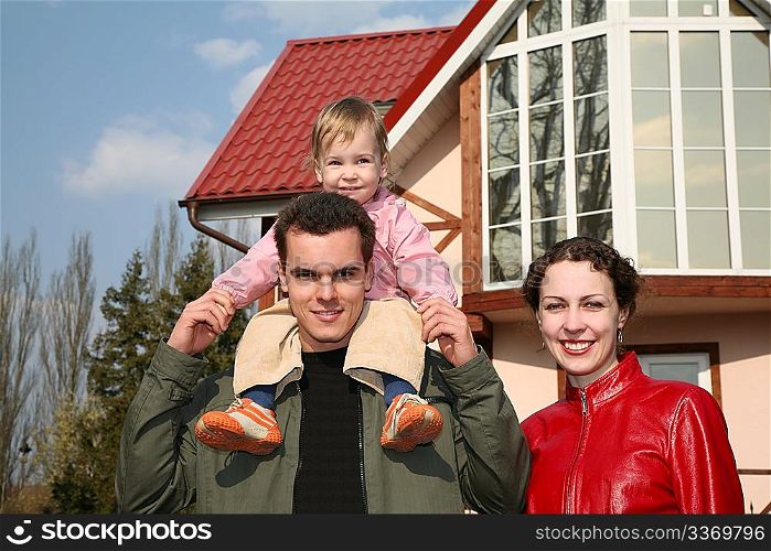 family with baby and house