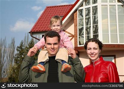 family with baby and house