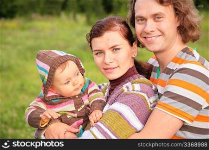 family with baby in stripe clothes in park
