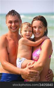 family with baby in water on beach