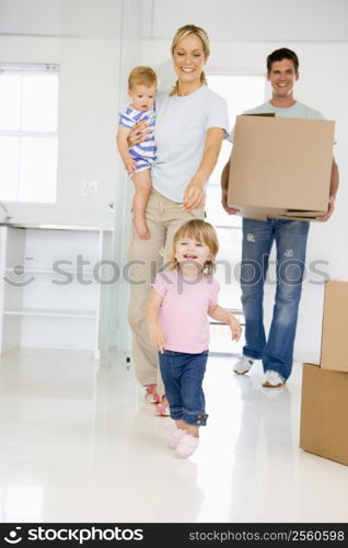 Family with box moving into new home smiling