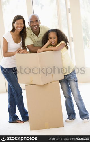 Family with boxes in new home smiling