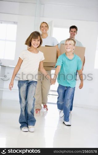 Family with boxes moving into new home smiling