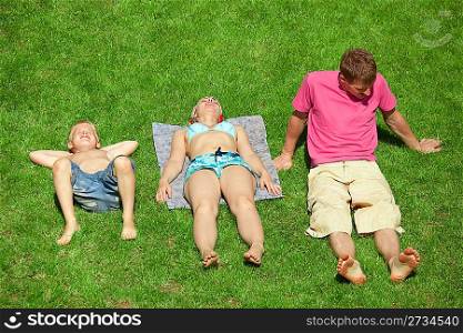 Family with boy resting on the grass, view from up