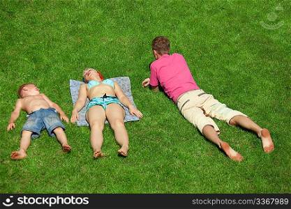 Family with boy resting on the grass, view from up