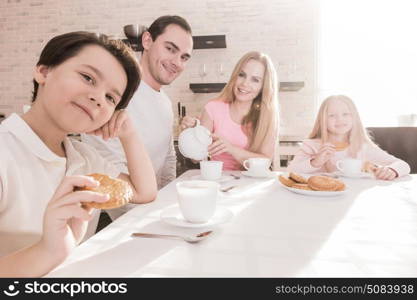 Family with children having breakfast. Happy family with children having breakfast at home