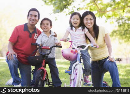 Family with children on bikes outdoors smiling