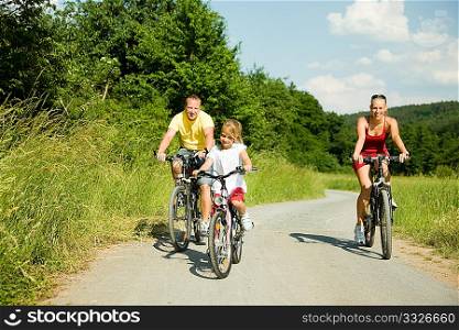 family with kids riding their bicycles