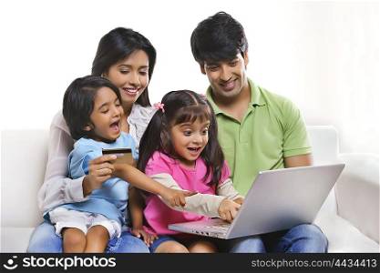 Family with laptop and credit card