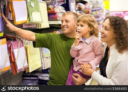 family with little girl buy bedding in supermarket