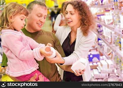 family with little girl buy milk in supermarket