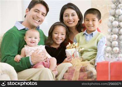 Family With New Born,Sitting On Sofa,Holding Christmas Gift