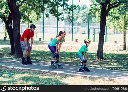 Family with one child roller skating in park