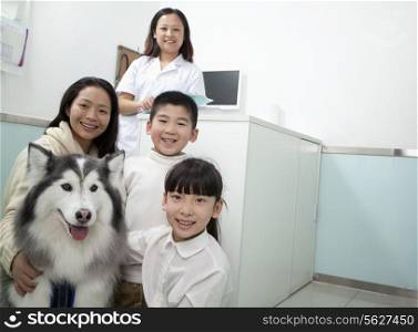 Family with pet dog in veterinarian&rsquo;s office