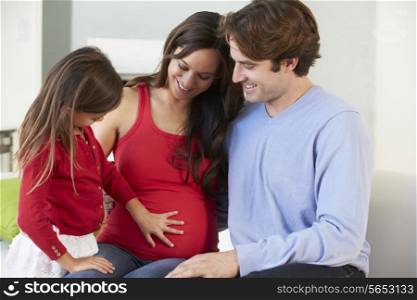 Family With Pregnant Mother Relaxing On Sofa Together