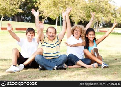 Family with raised hands enjoying in park...