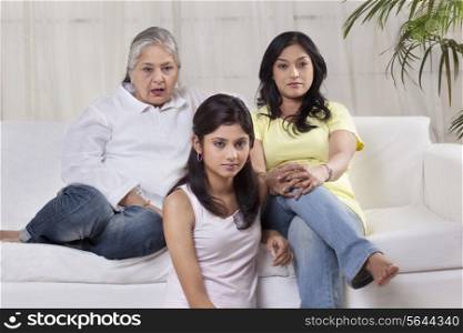 Family with serious expression watching television