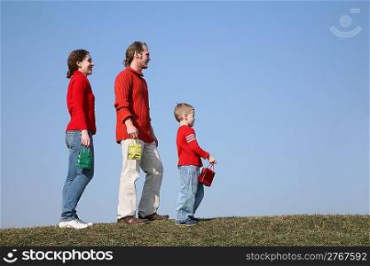 family with small bags on meadow