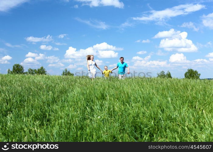 family with son in summer day on the meadow