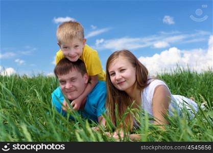 family with son in summer day on the meadow