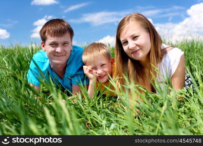 family with son in summer day on the meadow