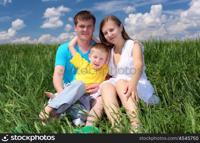 family with son in summer day on the meadow