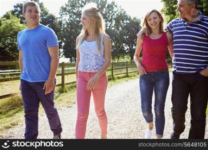 Family With Teenage Children Walking In Countryside