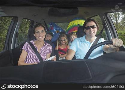 Family with three children (5-11) in car interior, portrait