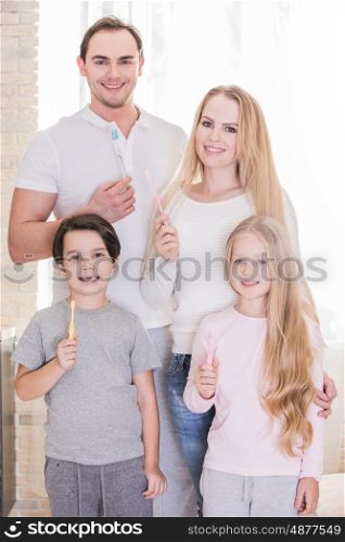 Family with toothbrushes. Happy family of four people with toothbrushes
