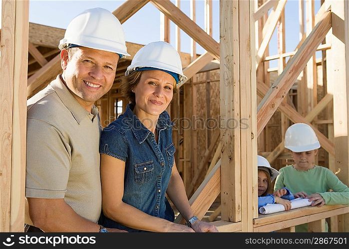 Family with two children (6-9) at construction site, portrait