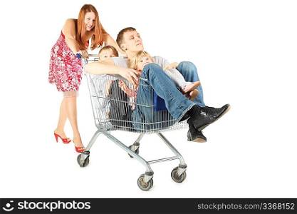 family with two children. father with son and daughter is sitting in shopping basket. woman is smiling. isolated.