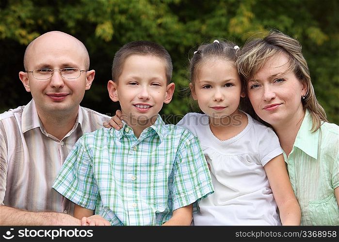 family with two children in early fall park. father, mother, little boy and girl