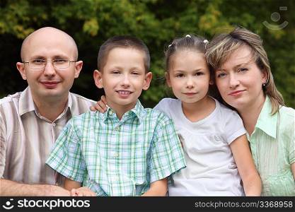 family with two children in early fall park. father, mother, little boy and girl
