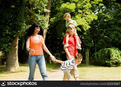 Family with two kids having a walk in the park