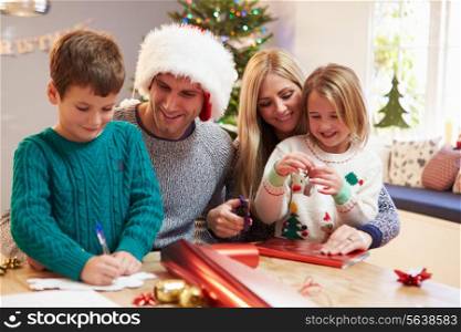 Family Wrapping Christmas Gifts At Home