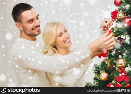 family, x-mas, winter holidays and people concept - happy couple decorating christmas tree at home