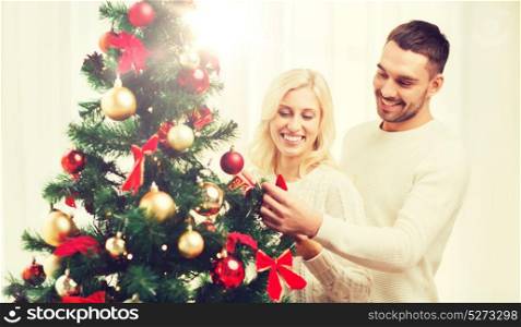 family, x-mas, winter holidays and people concept - happy couple decorating christmas tree at home. happy couple decorating christmas tree at home