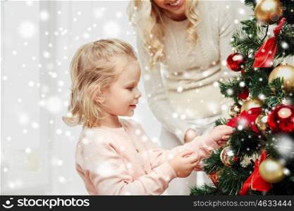 family, x-mas, winter holidays and people concept - happy mother and little daughter decorating christmas tree at home