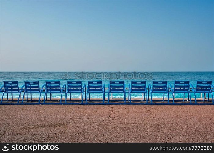 Famous blue chairs bench on beach in the morning. Nice, France. Famous blue chairs on beach of Nice, France