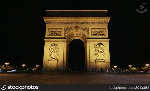 Famous Champs-Elysees arch at night. The famous Champs-Elysees arch illuminated with bright lights at night and street in foreground